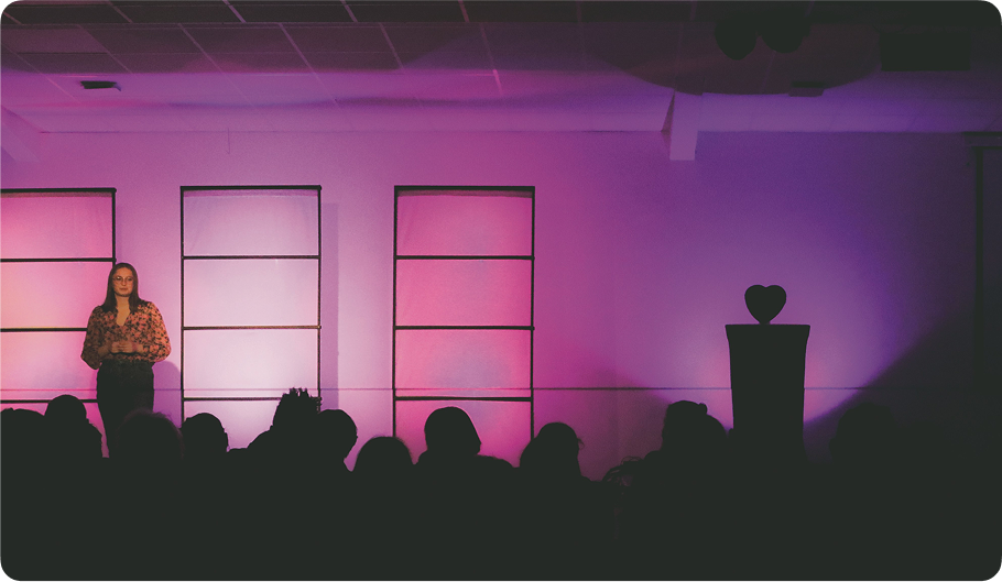 Person speaking on stage at a conference