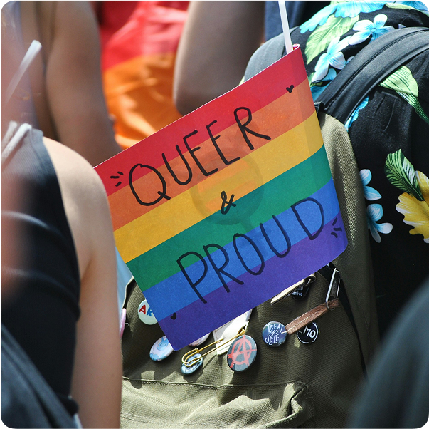 Rainbow flag with the words "Queer and Proud" on it